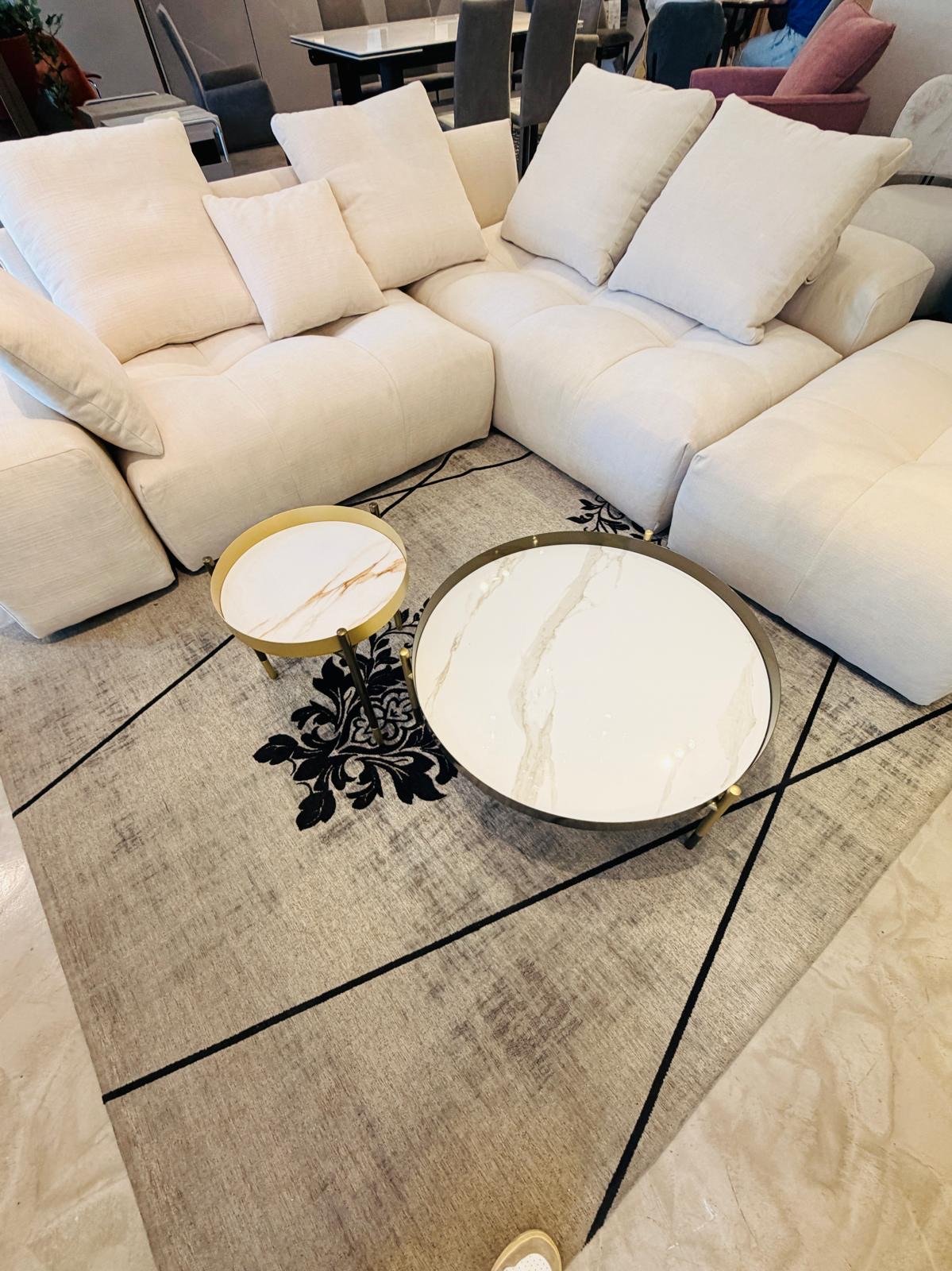 Divano angolare Saba in tessuto bianco panna con tavolini in marmo, nello showroom Home & Design di Largo Valtournanche 30 a Roma
